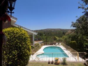 a swimming pool in front of a house at Cabañas La Morada de Tanti in Tanti