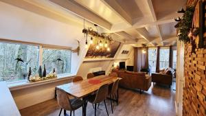 Un comedor con mesa y sillas de madera. en de bosdriehoek II, en Durbuy