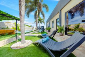 a patio with a hammock and a palm tree at Palm Beach Sea La Vie Suites in Palm-Eagle Beach