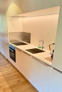 a white kitchen with a sink and a stove at Mellau Apartments in Mellau