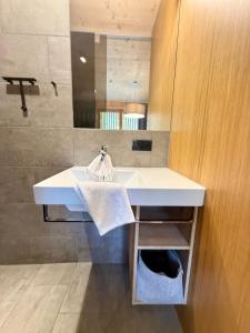 a bathroom with a white sink and a mirror at Mellau Apartments in Mellau