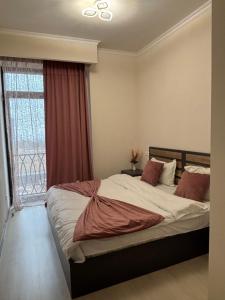 a bedroom with a large bed with a window at Alvina Complex s in Tsaghkadzor