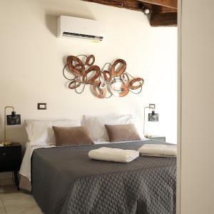 a bedroom with a large bed with a fan at Sikelìa Apartment in Carini