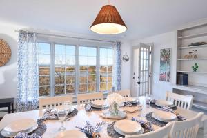 a dining room with a table and chairs and a window at Beautiful Water Views Dogs Welcome in Truro