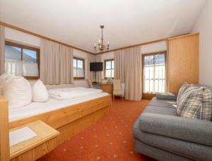 pokój hotelowy z łóżkiem i kanapą w obiekcie Hof Unterhuben w mieście Fügenberg