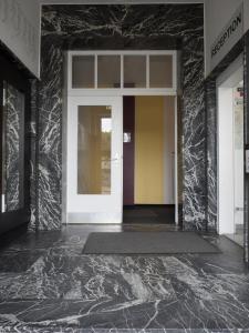 una entrada a un edificio con una puerta blanca en Hotel Westend, en Colonia