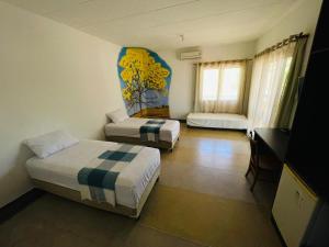 a hotel room with two beds and a television at Recanto Macambira in Delmiro Gouveia +23 photos