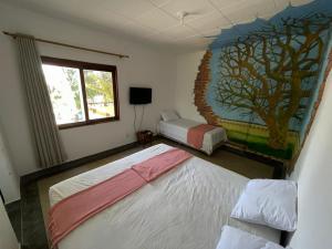 a bedroom with two beds and a painting on the wall at Recanto Macambira in Delmiro Gouveia