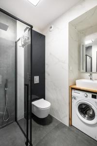 bagno con servizi igienici, lavandino e lavatrice di Apartamenty Platinex 2 a Cracovia