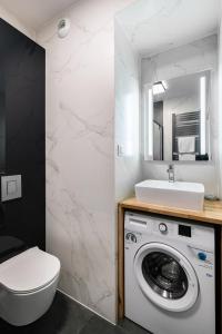 un bagno con lavatrice e lavandino di Apartamenty Platinex 2 a Cracovia