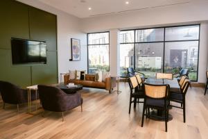 ein Wohnzimmer mit Tisch, Stühlen und Sofa in der Unterkunft Placemakr Huntsville - MidCity District in Huntsville