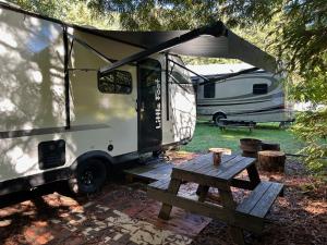 een witte camper met een picknicktafel en een aanhanger bij Little Foot RV in Klamath