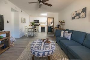 ein Wohnzimmer mit einem blauen Sofa und einem Tisch in der Unterkunft Renegade 236 - 3 minute walk to FSU in Tallahassee