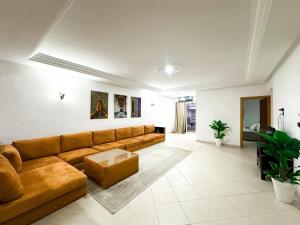 Modern and Cozy Beach Facing 2BR Apt in La Tulipe Complex, Tangier في Charf: غرفة معيشة بها أريكة وطاولة +صورتان