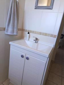 莫塞尔湾Hartenbos - Bayview 230m from beach的带白色水槽和镜子的浴室