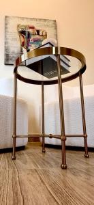 Una mesa de cristal con patas doradas delante de un sofá. en Irooms770, en Haifa