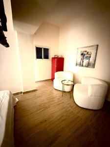 ein Zimmer mit zwei weißen Stühlen und einem roten Schrank in der Unterkunft Irooms770-Mamad downstairs in Haifa