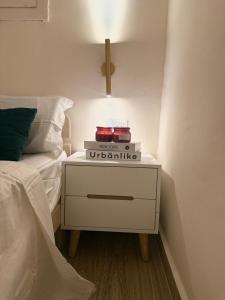 Una mesita de noche con libros al lado de una cama. en Irooms770, en Haifa 13 fotos más