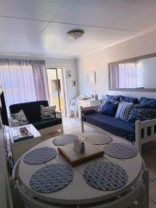 莫塞尔湾Hartenbos - Bayview 230m from beach的客厅里有一张沙发和一张桌子。