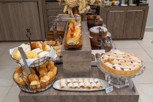 a buffet of different types of bread and pies at Concept Hotel Flat in Balneário Camboriú