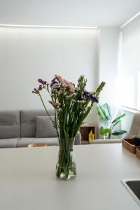 a vase of flowers on a table in a living room at Luxury Gran Vía centro Murcia in Murcia +22 photos