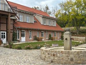 ein Backsteinhaus mit einem Brunnen davor in der Unterkunft Exterhof in Rinteln