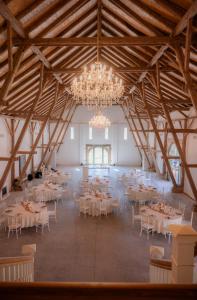 ein großer Bankettsaal mit weißen Tischen und Kronleuchtern in der Unterkunft Exterhof in Rinteln