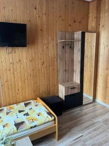 ein Schlafzimmer mit einem Bett und einer Holzwand in der Unterkunft Pokoje Gościnne in Ujsoły