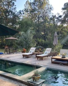 a backyard with a pool and chairs and a table at Rancho el Capricho in Valle de Bravo