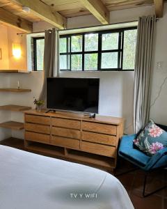 a living room with a tv and a dresser with a flat screen at Rancho el Capricho in Valle de Bravo