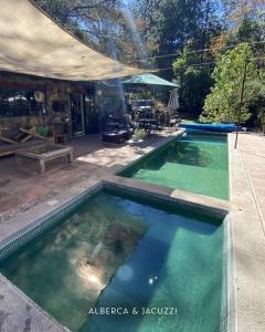 a swimming pool with green water in a yard at Rancho el Capricho in Valle de Bravo