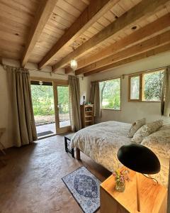a bedroom with a large bed in a room with windows at Rancho el Capricho in Valle de Bravo
