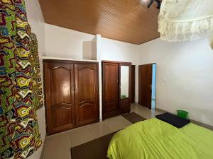 a bedroom with a green bed and wooden cabinets at Kalpho Art Center in Kigali +11 photos