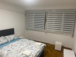 a bedroom with a bed and a window with blinds at SaS in Vrbas