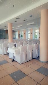 a large room with white chairs and a table at Hotel Leotar in Trebinje +102 photos