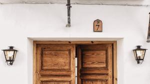 Casa Al Zaytun Pueblo في Canillas de Aceituno: باب ومصباحان على حائط أبيض