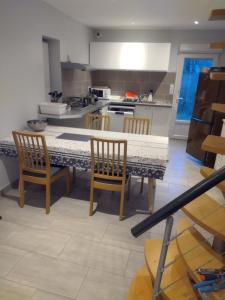 Una cocina con una mesa con sillas y una encimera. en vieille maison, en Forges-les-Bains