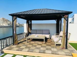 Un cenador con un banco y sillas en una terraza. en The home 4, en Sharm 4 fotos más