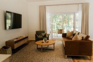 a living room with a couch and a table at Patryssenvalleij Farm and Cottages in Stellenbosch