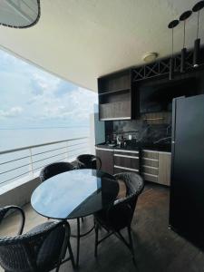 een keuken met een tafel en stoelen en de oceaan bij Tropical Executive Flat Vista da Orla in Manaus