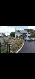 a house with a car parked in front of a street at Suíomh álainn in Kilgarvan