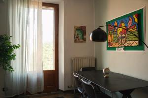 ein Esstisch mit Stühlen und ein Gemälde an der Wand in der Unterkunft Moderno Rifugio - Milano Rogoredo in Mailand