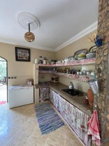 a kitchen with a counter with dishes on the shelves at Villa ayyur in Souira Guedima