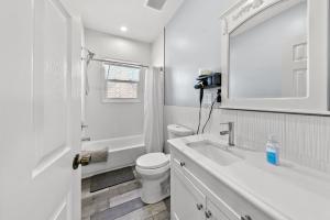 een witte badkamer met een toilet en een wastafel bij Cozy 3BR Home • Smart TV + Workspace in Dayton +21 foto's
