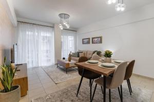 a dining room and living room with a table and chairs at Danellgio cozy nest apartment in Chalkida