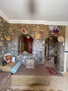 a living room with a stone wall with a fireplace at Villa ayyur in Souira Guedima
