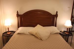 a bed with two lamps and two pillows on it at Memórias in Nogueira da Regedoura +73 photos