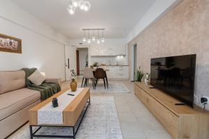 a living room with a couch and a large television at Danellgio cozy nest apartment in Chalkida