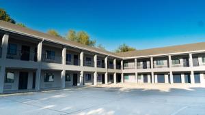 a large white building with a parking lot at Airway Inn - IAH Airport in Houston
