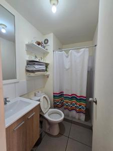 een badkamer met een wastafel, een toilet en een douche bij Los Nogales LS in Lima